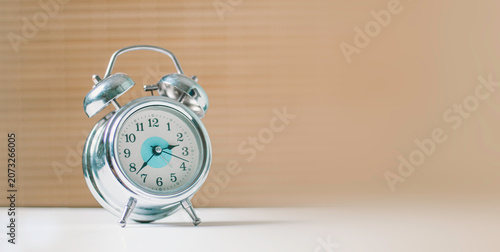 Obraz na plátně Silver retro alarm clock on white table with copy space