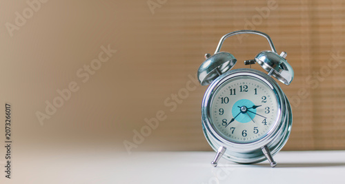 Картината върху платно Silver retro alarm clock on white table with copy space