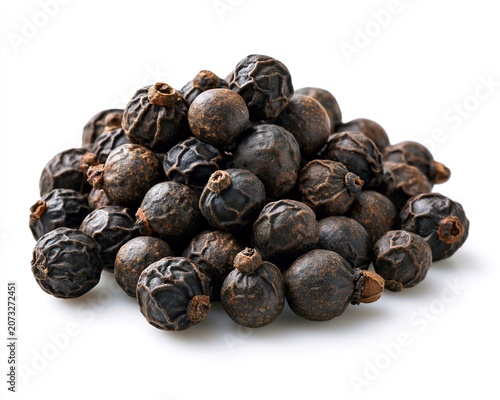 Black pepper pile, close-up view of dark peppercorns against white background.