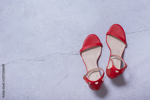 Tableau sur toile Red sandals placed on a light grey surface with copy space