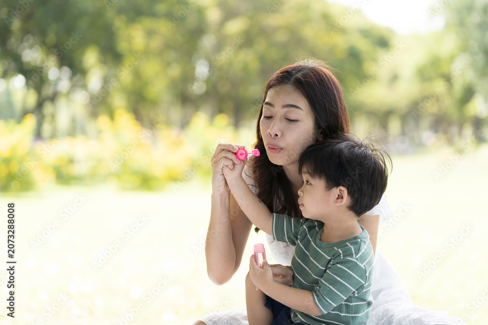 Obraz premium Asian family with mother and son having fun, enjoy, relaxing together outdoor on holiday