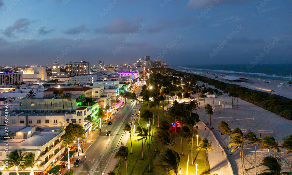 Fototapeta premium Summer vacation on Miami at night. Night travel in Miami beach, nightlife in tropical American city. Miami city at evening. Miami shoreline.