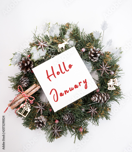 Festive holiday wreath adorned with pine cones, cinnamon sticks, and decorative elements, featuring a sign that reads 
