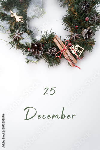 Festive Christmas wreath adorned with pinecones, cinnamon sticks, and decorative elements, featuring a date of December 25, symbolizing holiday celebration and joy