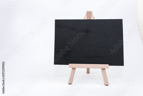 Blank black chalkboard on wooden easel, perfect for holiday messages, festive greetings, or seasonal decorations, ideal for Christmas and New Year celebrations with copy space