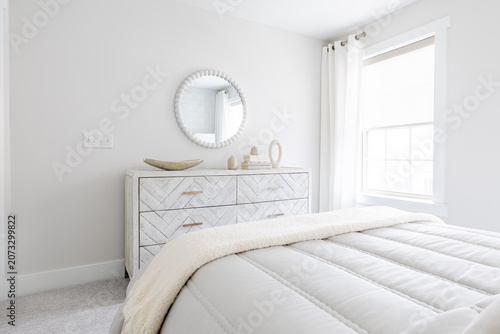 Serene White Bedroom with Chevron Dresser, Round Mirror and Fluffy White Bedding

