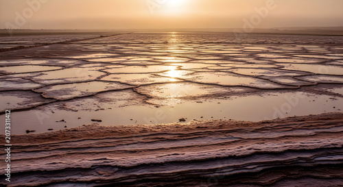 Sunset over calm ocean waves with golden reflection