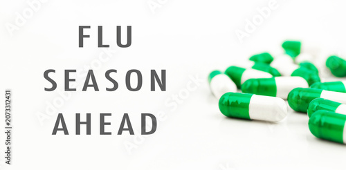 Green capsules promoting flu season awareness on white background