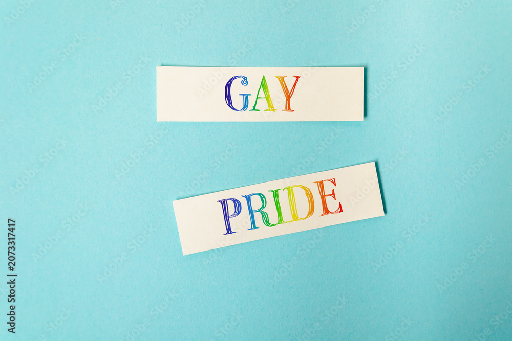 Naklejka premium Gay Pride Text in Rainbow Colors on Blue Background