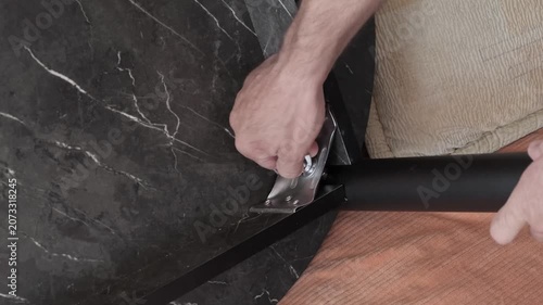 man screws a leg to the table
