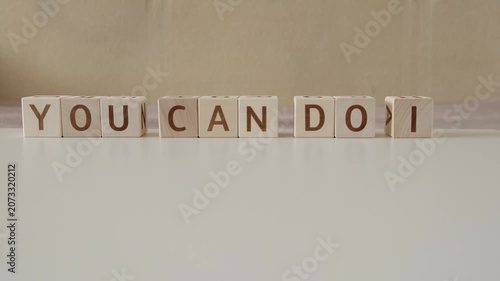 motivational phrase you can do it, laying out  by hand from letters on wooden cubes, slow motion
