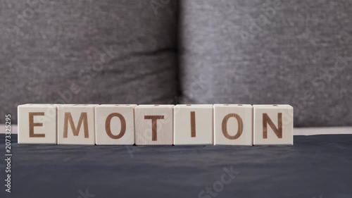 motivational word emotions, laying out  by hand from letters on wooden cubes, slow motion
