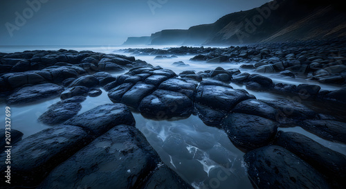 Rocky shoreline with ocean waves at dusk