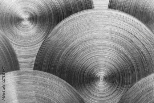 Close-up macro view of a brushed stainless steel sheet featuring an anisotropic texture with directional grain. The abstract metallic surface highlights industrial precision, material quality