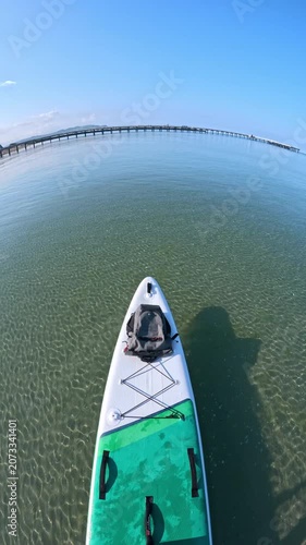 Stand up paddle boarding over crystal clear sea near beach