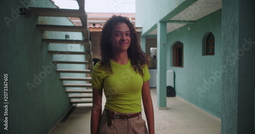 Photography Young teenager of African descent smiling warmly while standing in a courtyard,