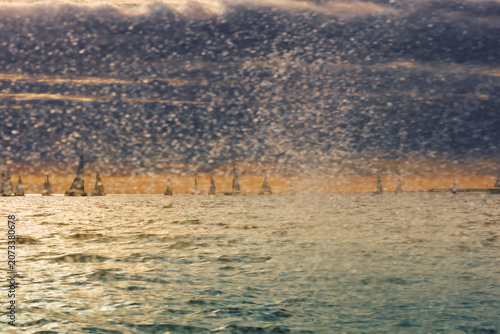 A lot of sailing boats through splashing water at sunset, Sailing regatta in the Gulf of Finland at sunset, hot race of several yachts, teamwork