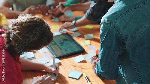 Tableau sur toile Top view of manager writing idea on sticky notes and explain idea about web design