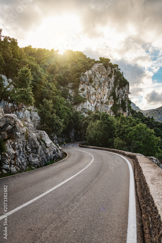 Winding road in summer mountains at sunset