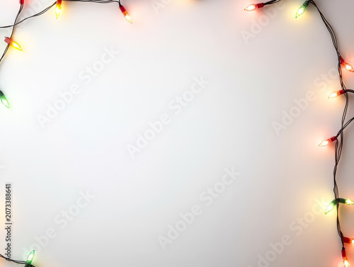 Colorful Christmas lights arranged in a ring shape on a white background. Studio photography with a festive theme. Suitable for holiday greeting cards, seasonal promotions, and festive decor.