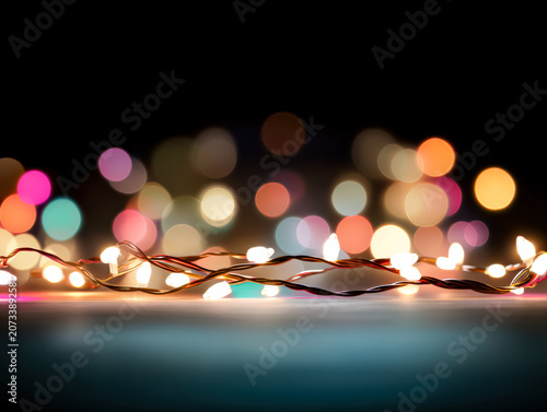 Colorful Christmas lights arranged in a ring shape against a blurred bokeh background. Studio photography with vibrant lighting effects. Suitable for holiday decorations, festive designs, and seasonal