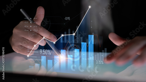 Foto A businessman closely examines stock market data on a tablet, utilizing digital graphs and charts to make informed decisions