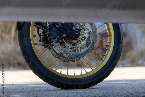 Motorcycle Wheel Tire Brake Disc Spokes and Suspension Close Up on Road