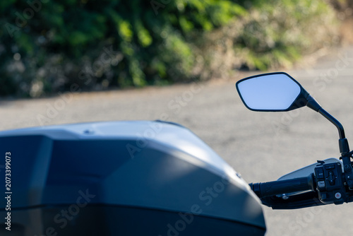Motorcycle Handlebar Mirror Controls and Phone Mount Close Up on Scenic Road