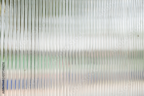 A Close up of corrugated glass texture with reflected,modern home decor,stylish home decor,Creative composition of living room,Wave glass vertical line pattern,Template.