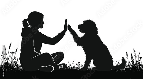 A black silhouette of a young girl giving a high five to her furry dog