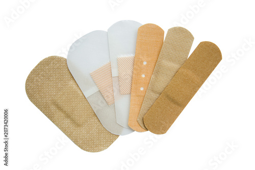 Medical plasters of different sizes and colors isolated on white.