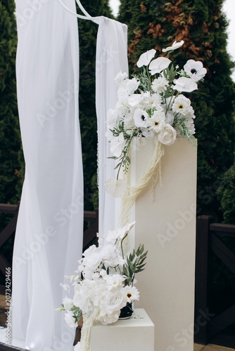 White wedding arch with floral decor at event