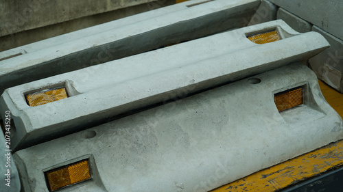 Concrete wheel stoppers with yellow reflectors close-up