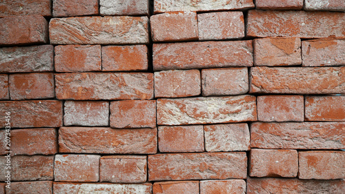 Full frame texture of stacked rustic red clay bricks