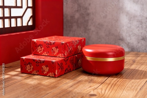 Red Floral Gift Boxes and Round Tin on Wooden Table