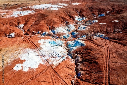 Aerial View of Red and Blue Rock Formations with Tire Tracks