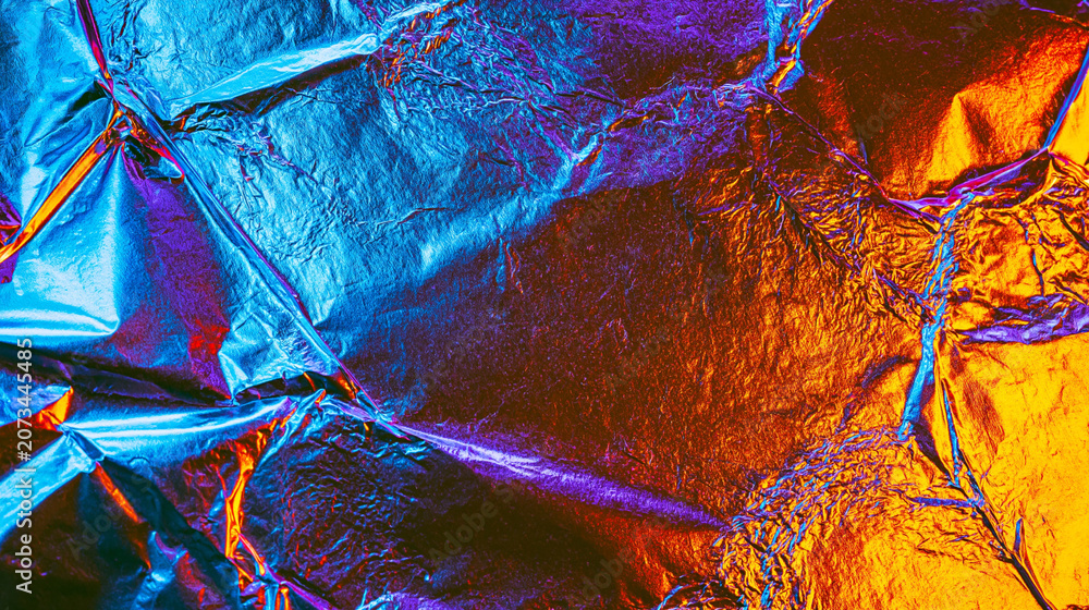 Naklejka premium Abstract crumpled metallic foil background with neon blue and copper lighting