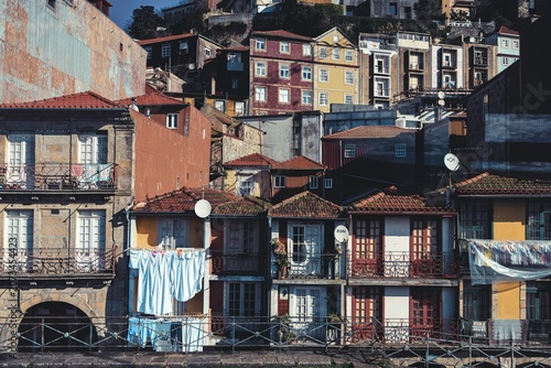 Historic buildings line the waterfront of Porto's Ribeira district, their colorful facades adorned with laundry hanging on lines