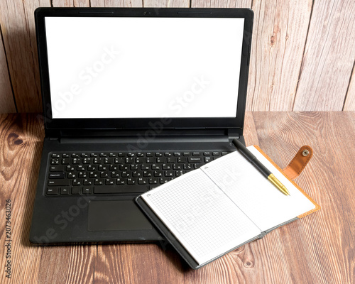 laptop with white screen and notebook on table