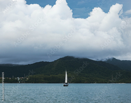 Tableau sur toile barco en el mar y grandes nubes