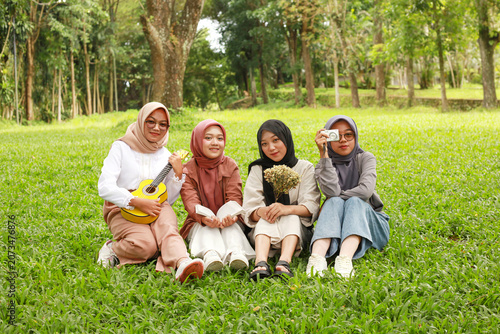 Konstfotografi Group of happy young Asian Muslim women in hijab walking and laughing together i