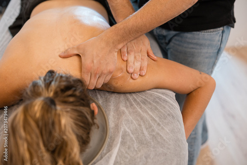 Quadro su tela Physiotherapist performing manual therapy on woman's shoulder