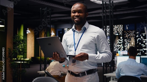 Konstfotografi Portrait of black business traveler in office managing schedules on laptop, organizing calendar appointments and meetings, Male entrepreneur ensuring profitability with company records