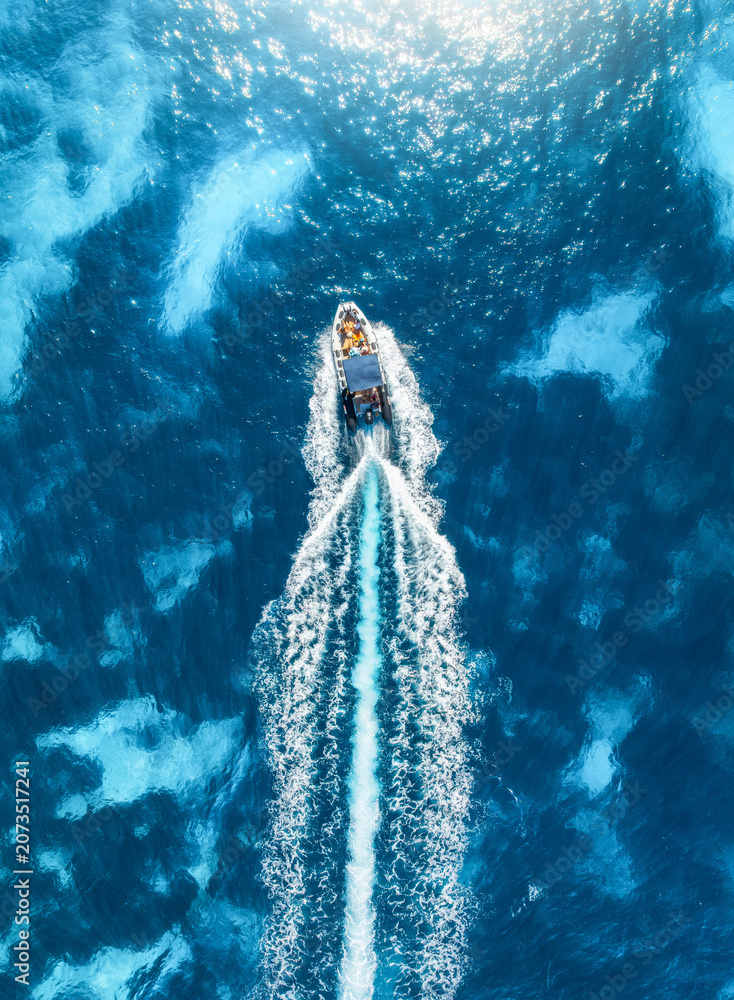 Obraz premium Aerial drone view of beautiful floating boat in blue sea on sunny day in summer. Mallorca island, Spain. Top down view of speed boat, sea, turquoise water. Travel. Tropical landscape. Yachting. Cruise