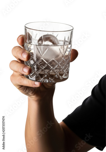 Extreme close-up of a caucasian hand raising a geometric cut crystal old-fashioned glass with gin and spherical ice, condensation, dramatic rim light, isolated on a white studio background. Concept
