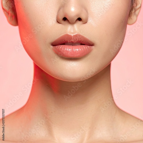 Close up of a womans lips and neck with soft lighting.