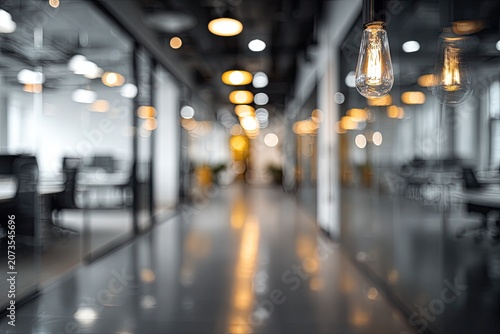 A blurred perspective showcases a modern interior space with hanging Edison-style light bulbs illuminating a long hallway, creating a warm and inviting atmosphere.