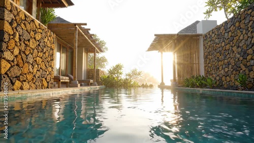 Private pool with stone wall and wooden pergola sunrise, tropical outdoor space with calm water reflection and warm sunlight