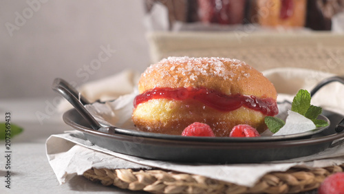 Sweet sugared donut filled with red berry jam