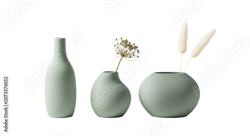 A trio of organic-shaped pale emerald green stoneware vases with heavily textured matte finishes and dried botanicals, displayed on a transparent surface, conveying a serene minimalist aesthetic